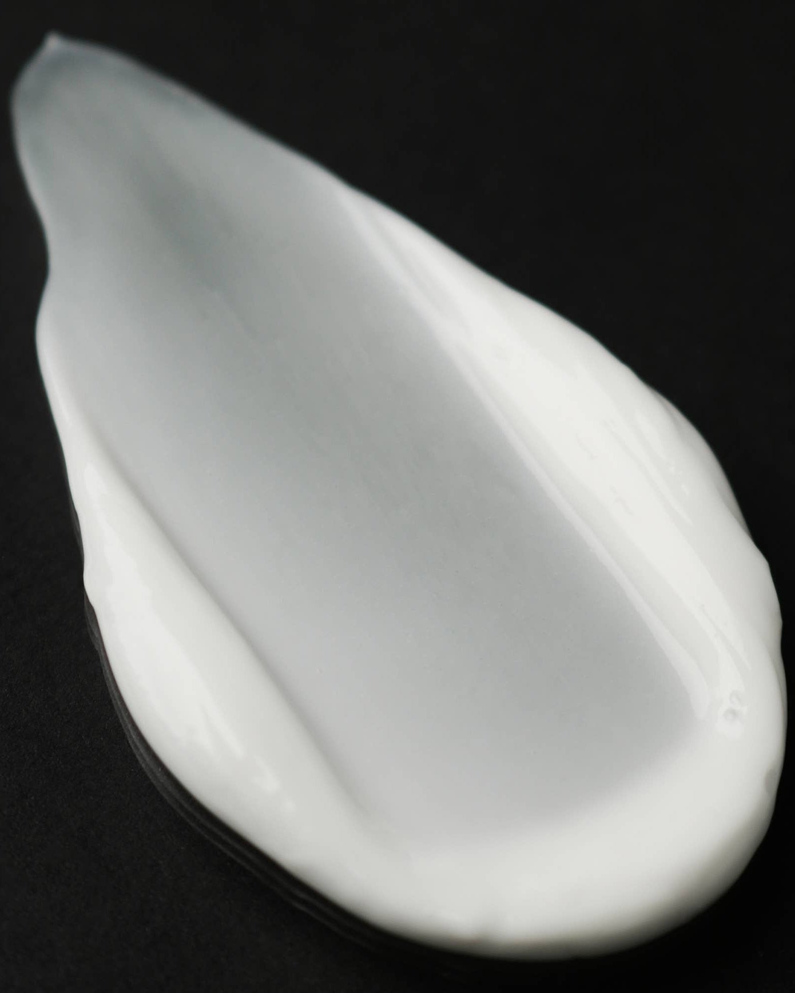 White ceramic teardrop-shaped object on a black background