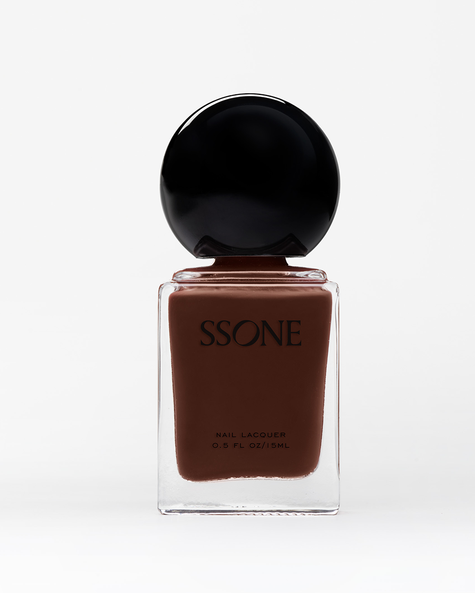 Brown nail polish bottle with black cap on a white background