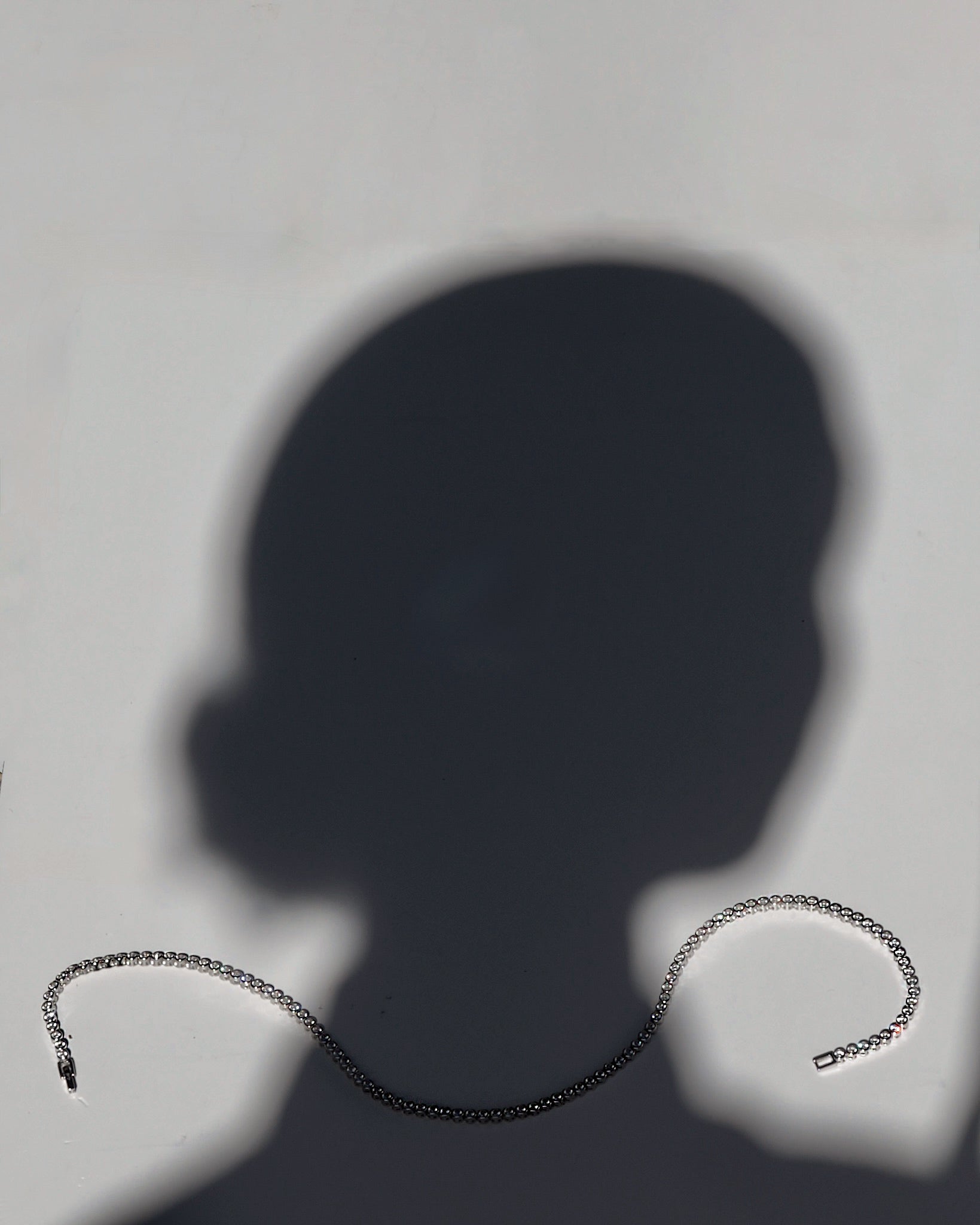 Silver chain necklace on a plain background