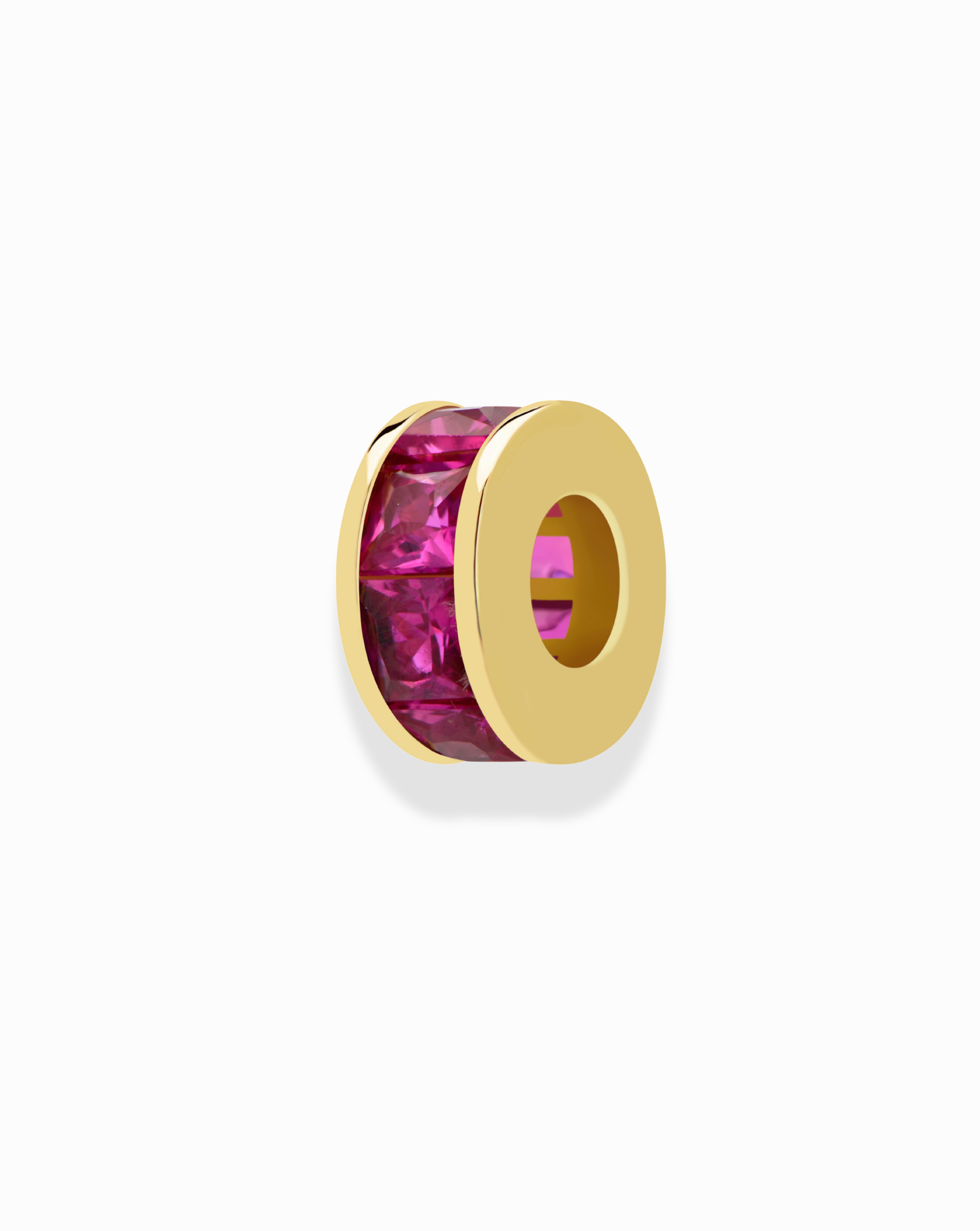 The Mod + Jo Este Birthstone Charm Spacer features a gold bead with a central row of pink gemstones, ideal for customizing necklaces. Shown on a white background.