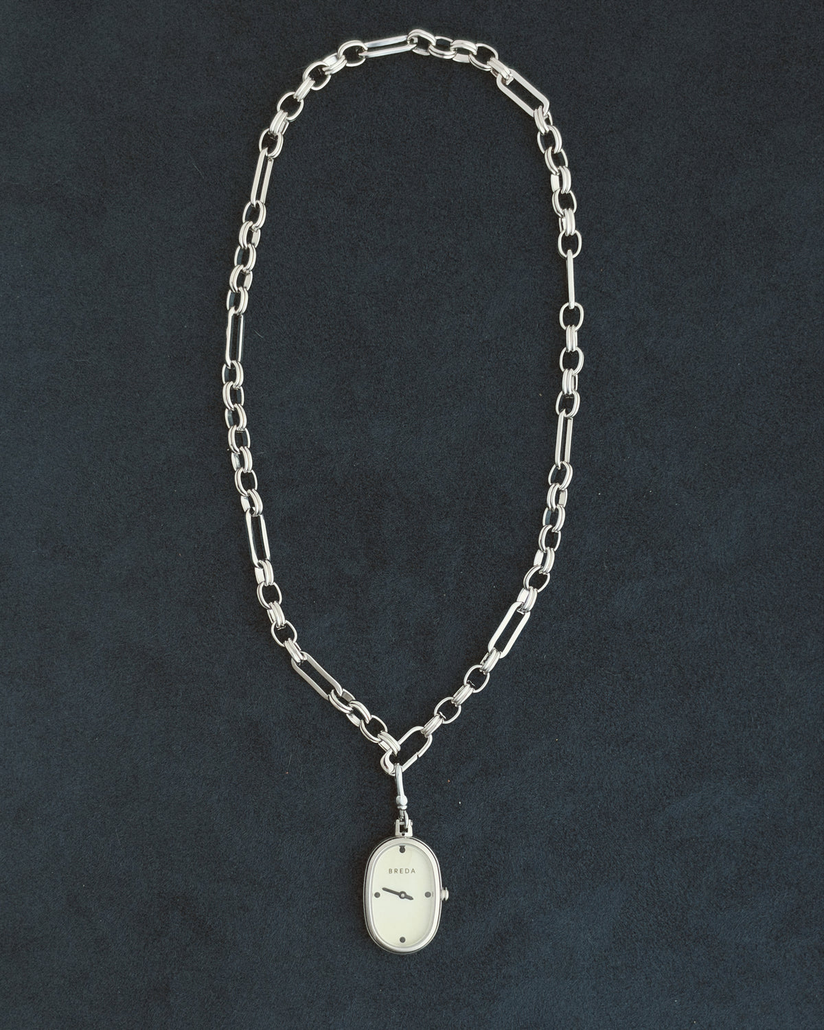 Silver oval Jane Time Charm by BREDA watch pendant on a matching chain necklace.