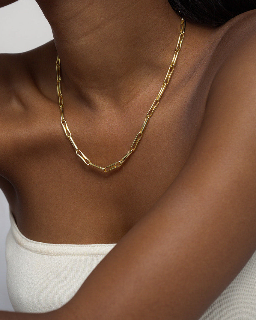 A person wearing a white strapless top and the Mod + Jo Molly Elongated Link Chain Necklace, styled as an everyday accessory, against a plain background.