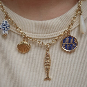 Gold necklace with various charms including a fish, shell, and blue and gold 'Bonnie Chance' charm.