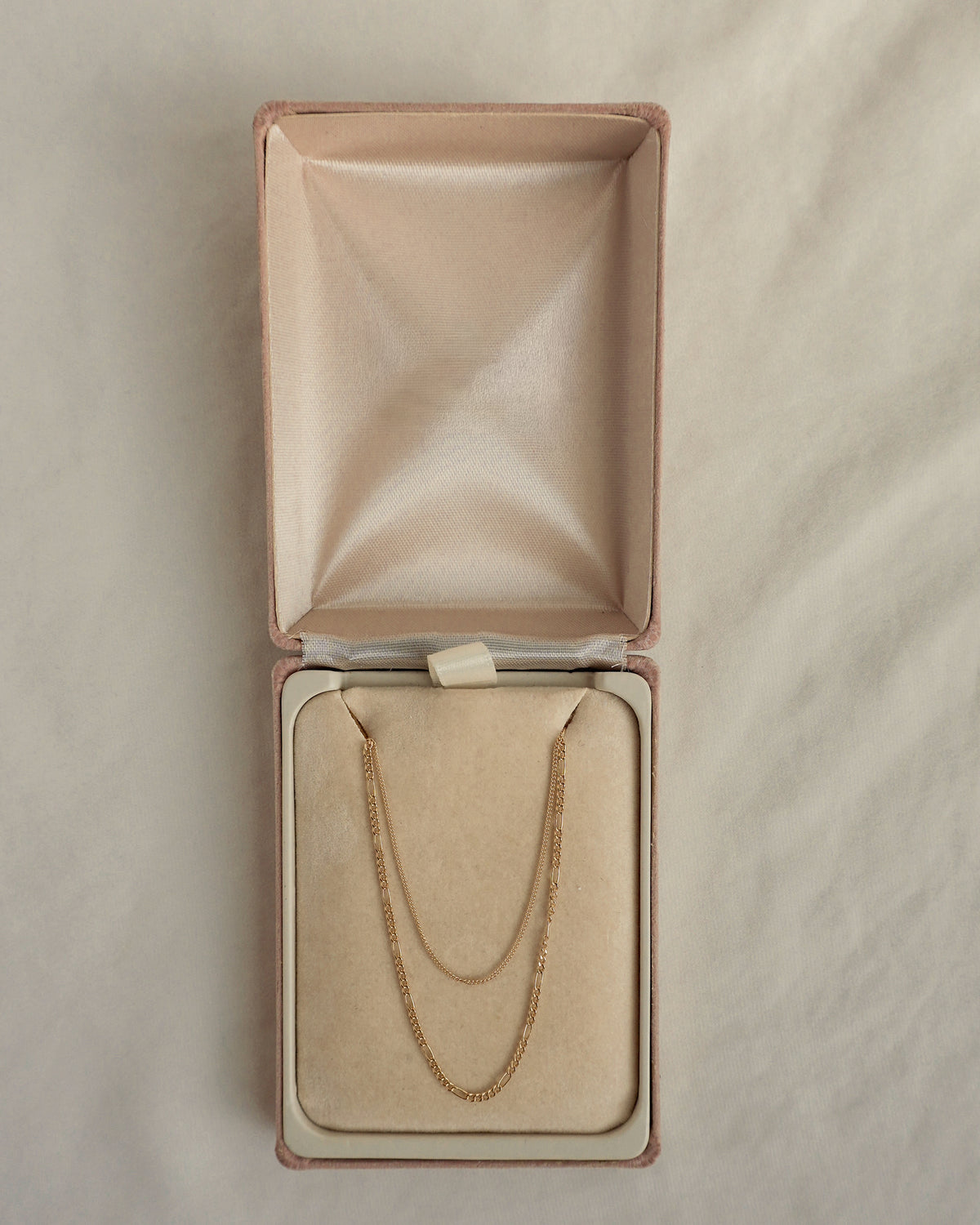 A delicate gold Lily + Gavin Set double-chain necklace featuring a curb and figaro chain, displayed in an open, lined jewelry box by Mod + Jo.