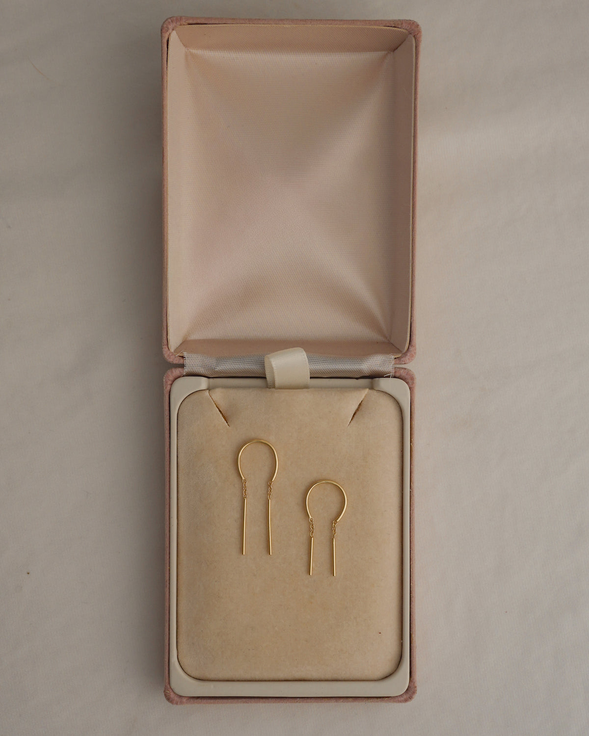 Mila Smooth Threader Huggies by Mod + Jo, a pair of 14k gold-plated arch-shaped threader earrings in an open jewelry box.