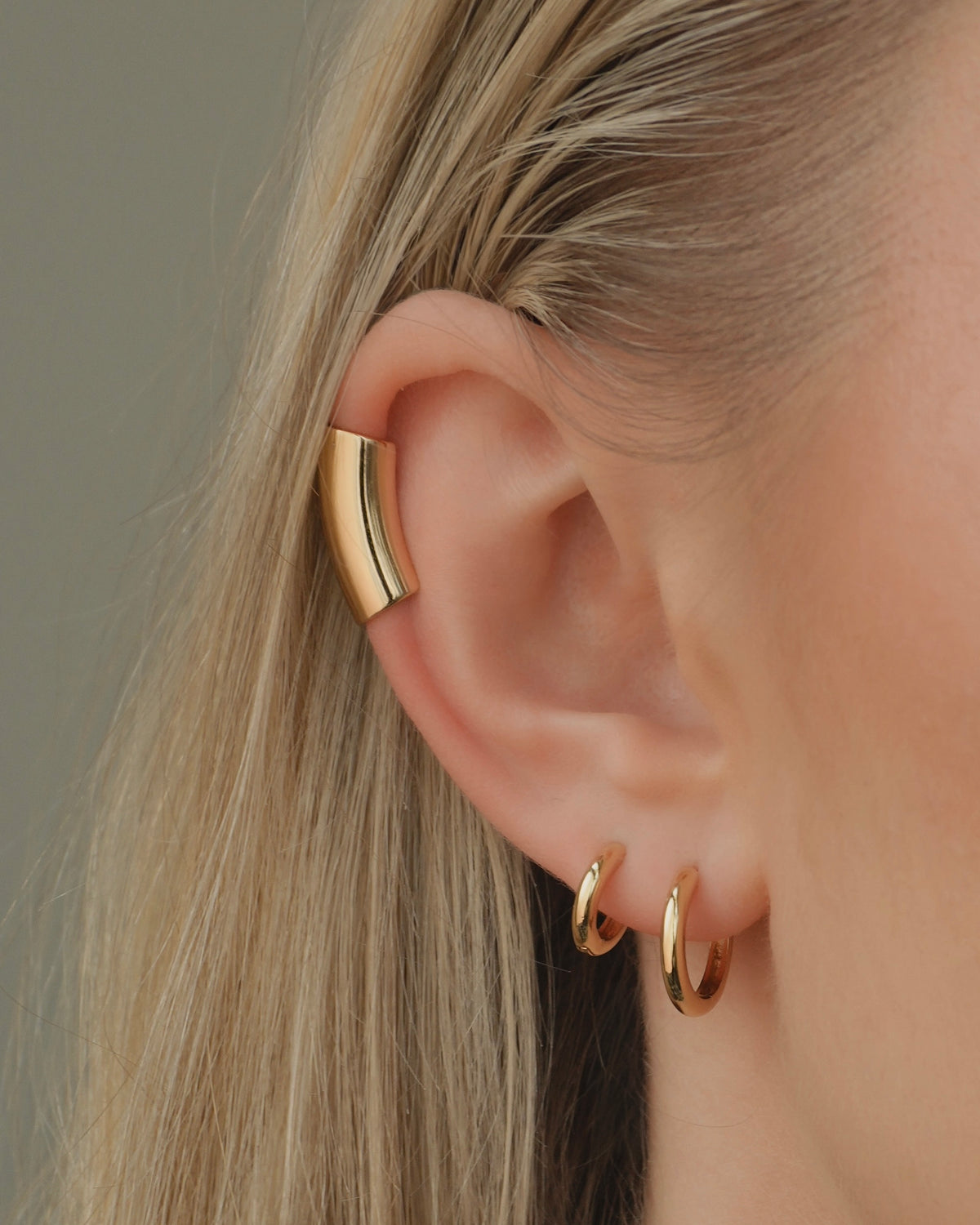 The Reneé + Lennon Set features a gold tube helix ear cuff on the upper cartilage and two smooth gold huggies in the lobe.