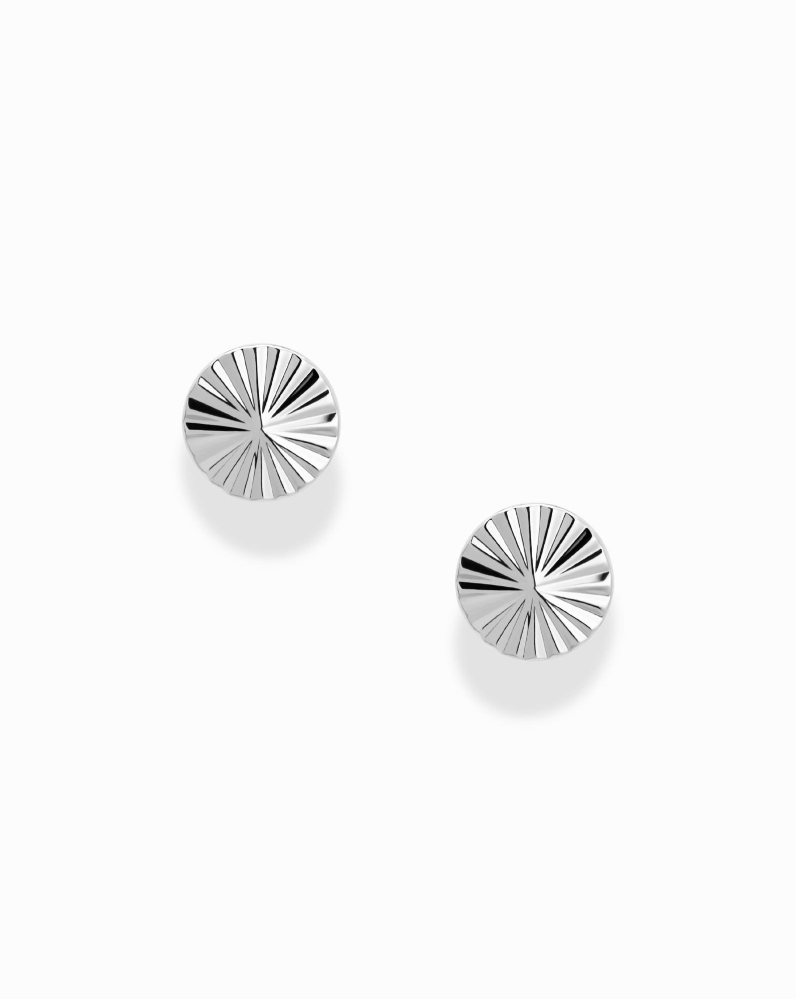 Two round Dela Fluted Studs by Mod + Jo, featuring a rhodium-plated sunburst pattern, displayed against a plain white background.