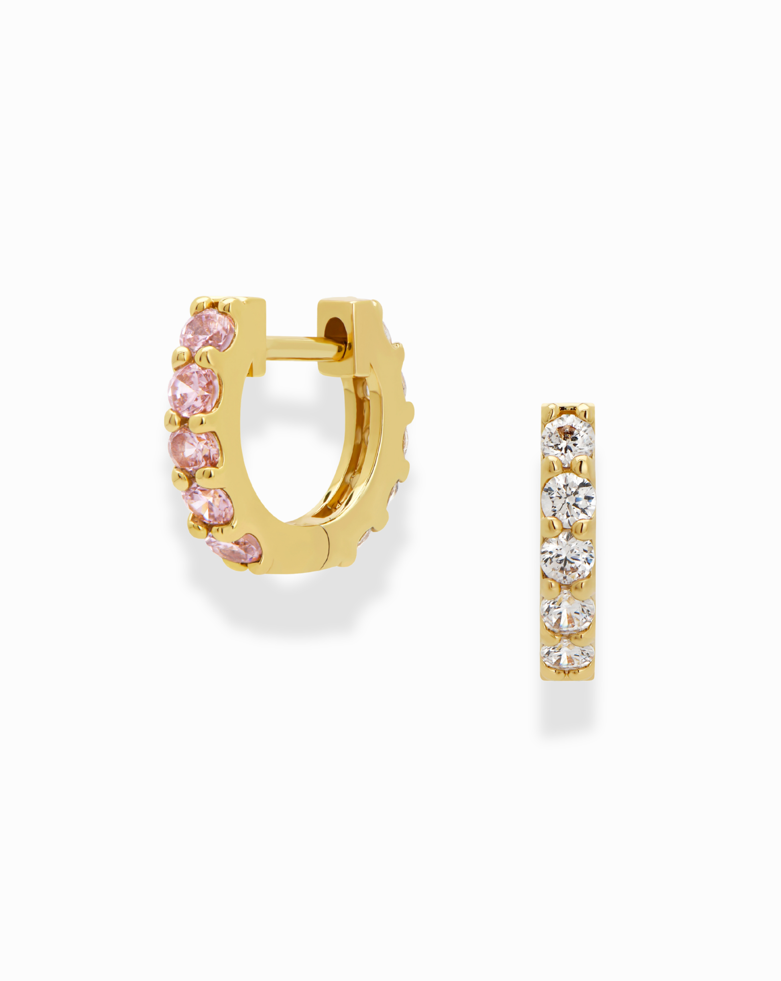 The Harlow Reversible Birthstone Huggies by Mod + Jo are small gold-plated hoops, with one side set with pink gemstones and the other with clear white stones, shown on a white background.