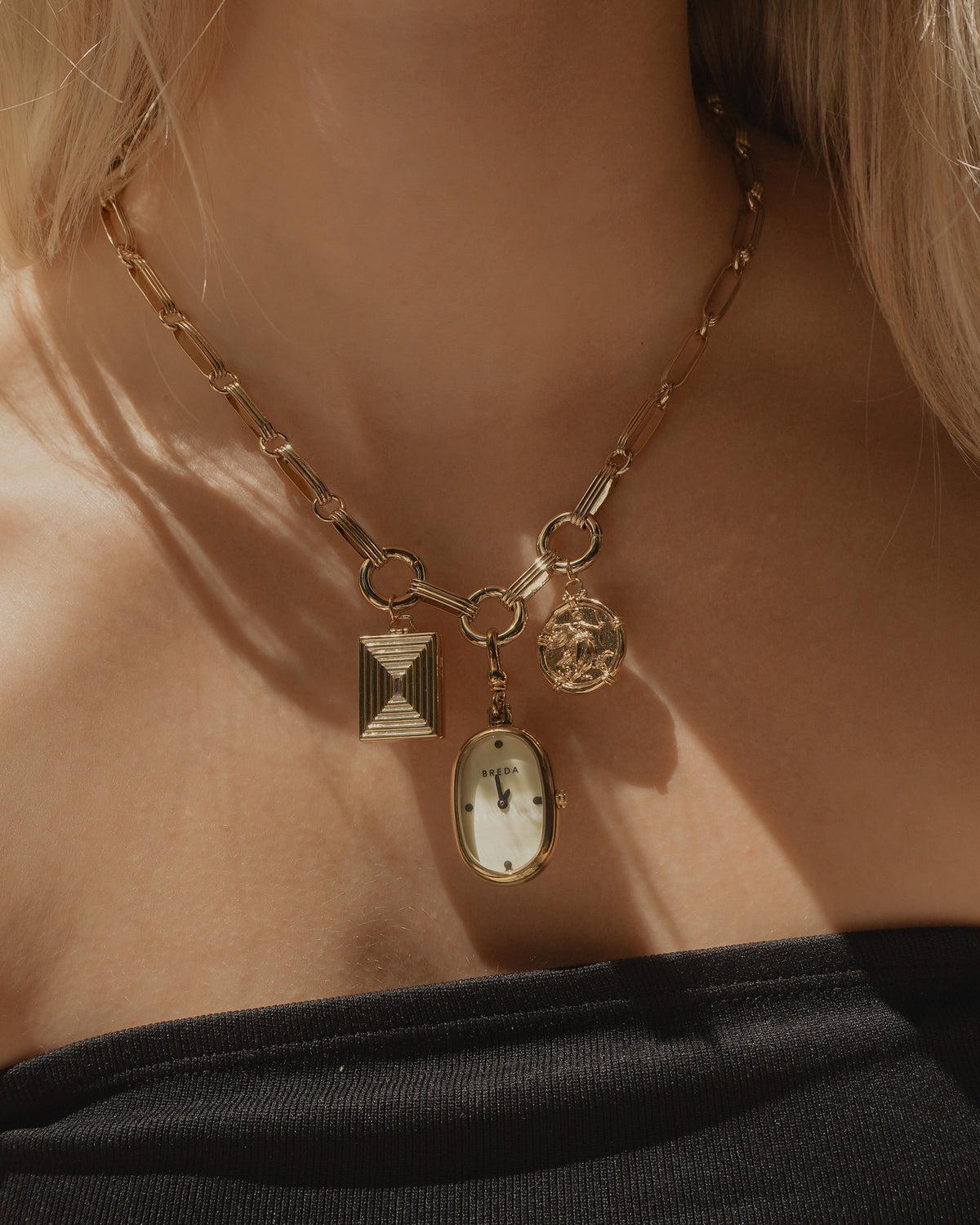 Mod + Jo Jagger Charm Clip Necklace featuring a 14k gold ball chain, a small rectangular charm, a round coin charm, and an oval watch pendant.