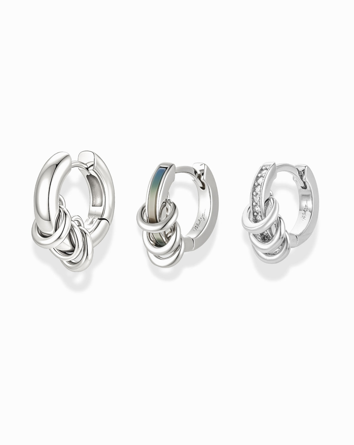 Levi Huggies Gift Set featuring three silver huggie hoop earrings, each with a cluster of three small linked rings as part of an ear stack.