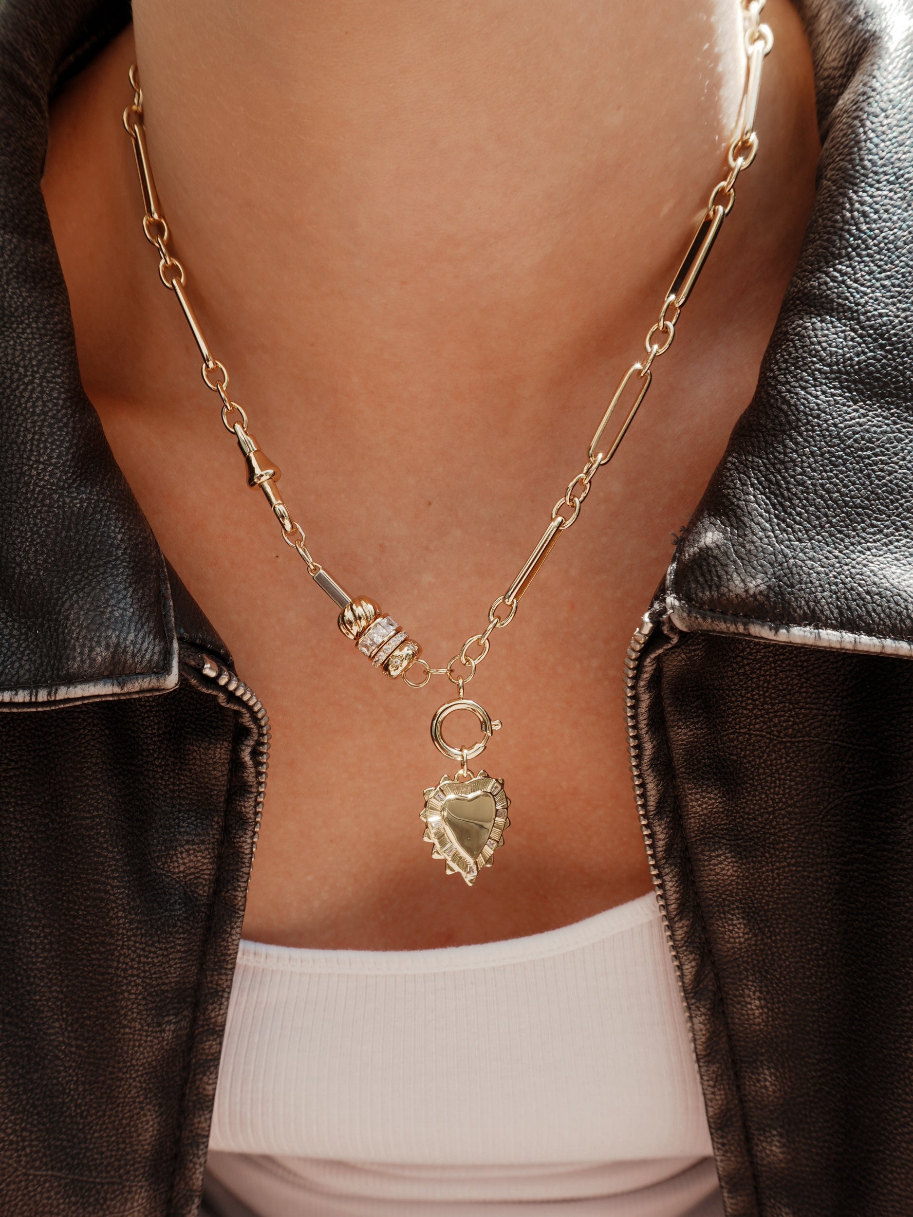 A close-up of a person wearing the Mod + Jo Liam Space Bar Chain Necklace, layered with beaded accents over a white top and dark leather jacket.