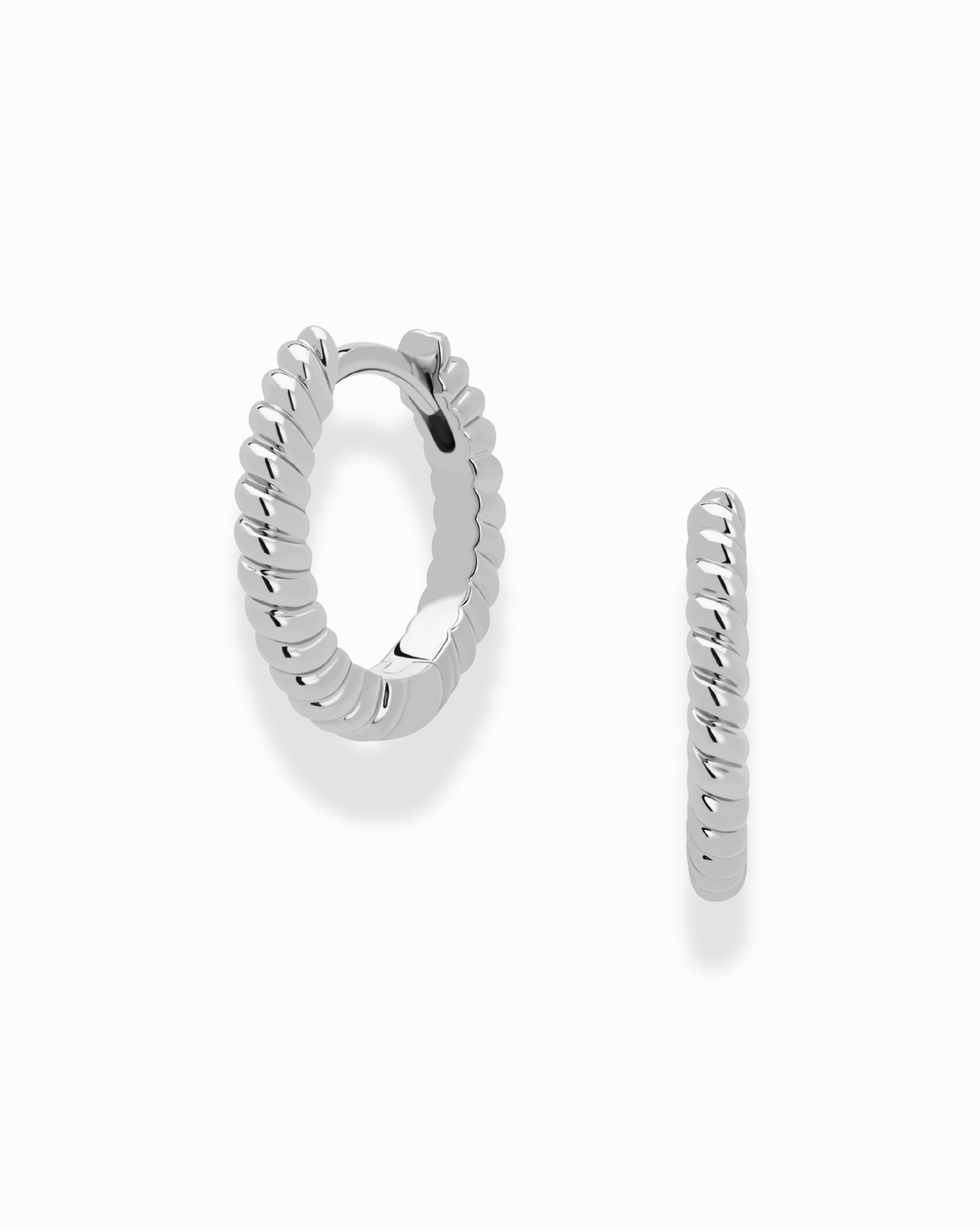 Shown against a white background, the Mod + Jo Grande Margaux Stacking Hoops feature tarnish-resistant silver in a twisted, rope-inspired design. One hoop faces forward and the other sideways—ideal for stacking earring styles.