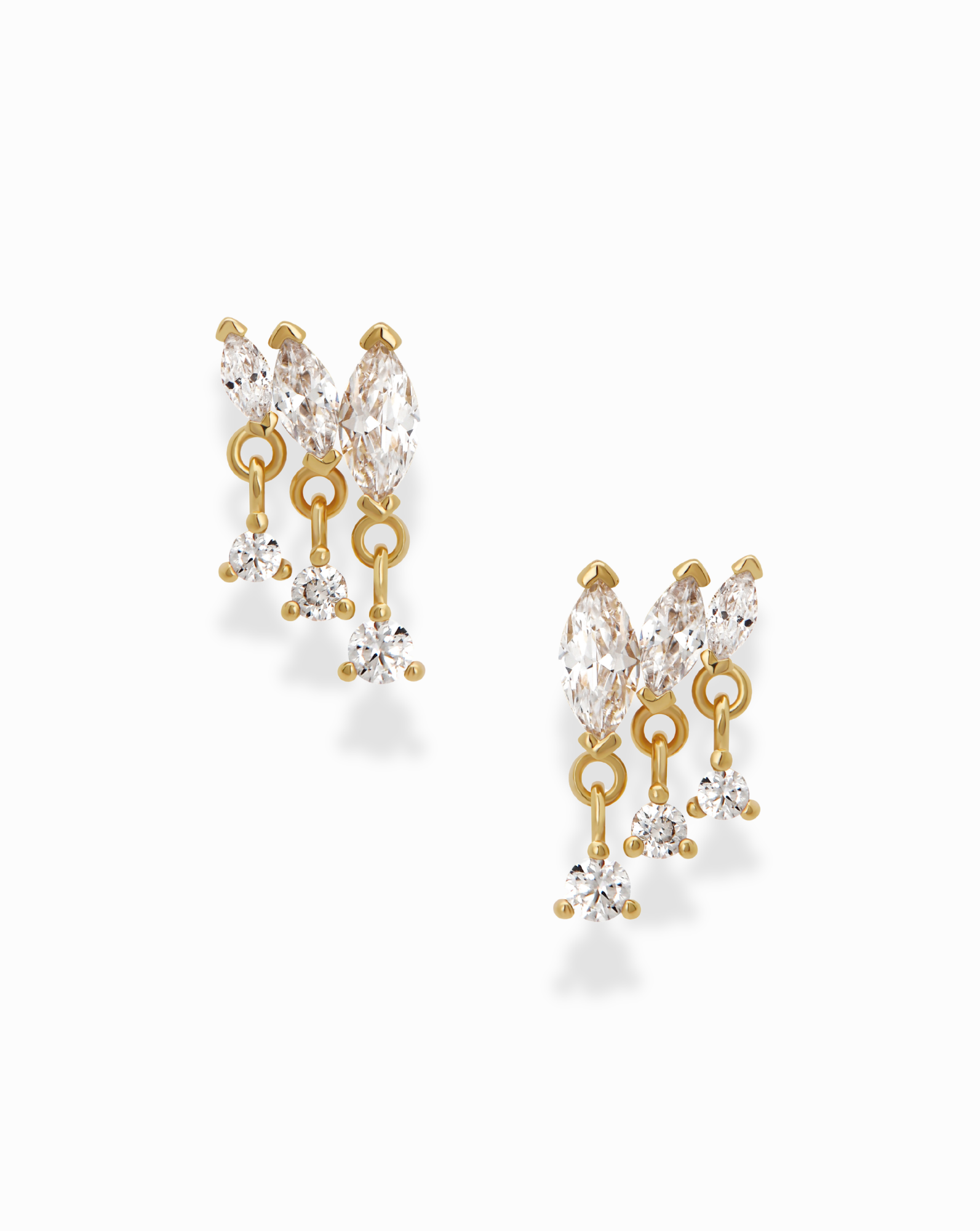 Introducing the Gabby Marquise Dangle Studs by Mod + Jo—gold-plated earrings featuring clear teardrop, marquise, and round cubic zirconia gemstones. Each earring showcases two prominent stones at the top and three sparkling gems dangling below, elegantly designed to catch the light against a plain white background.