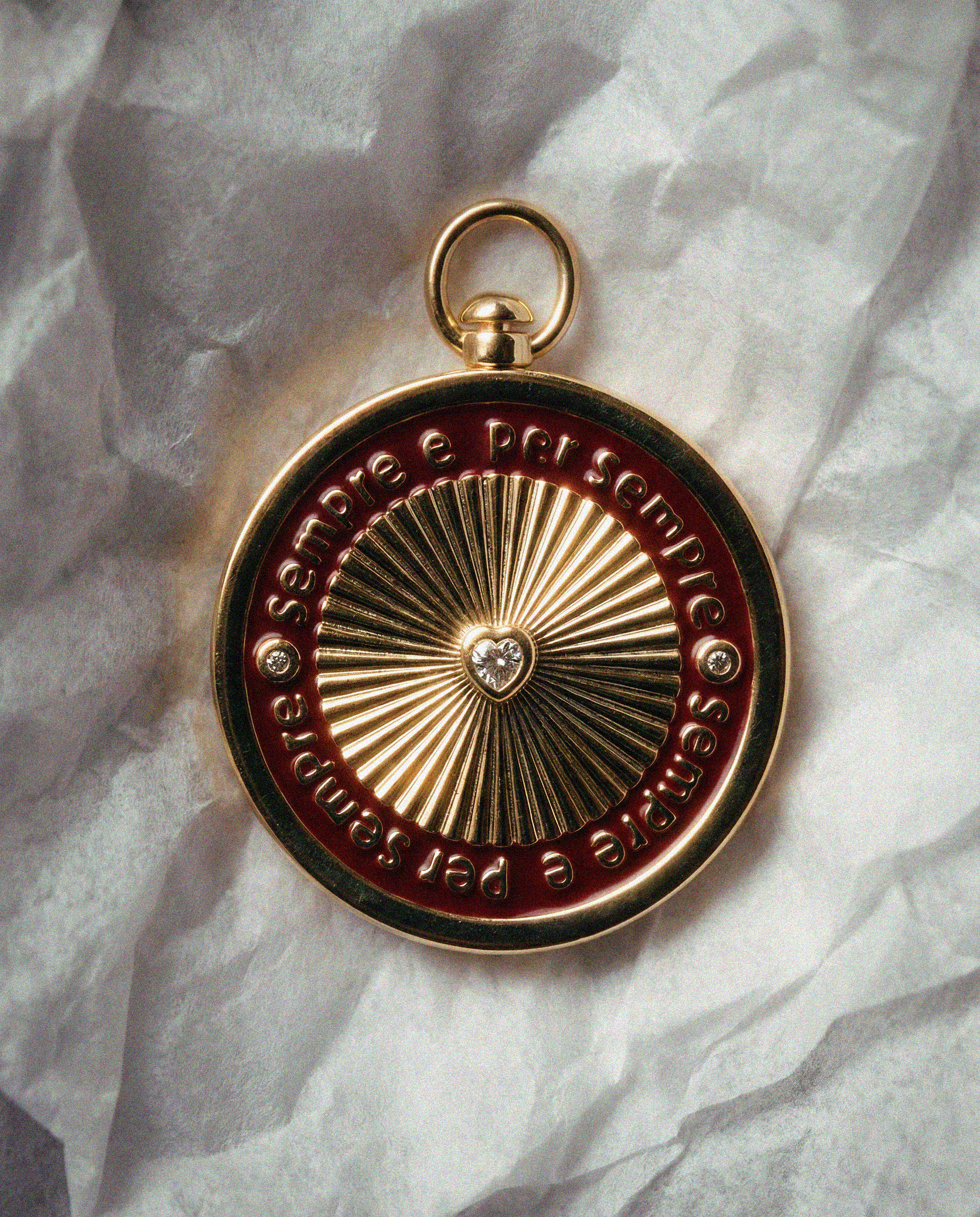 Gold and red medallion with engraved text that says sepre e per sepre on a textured white background