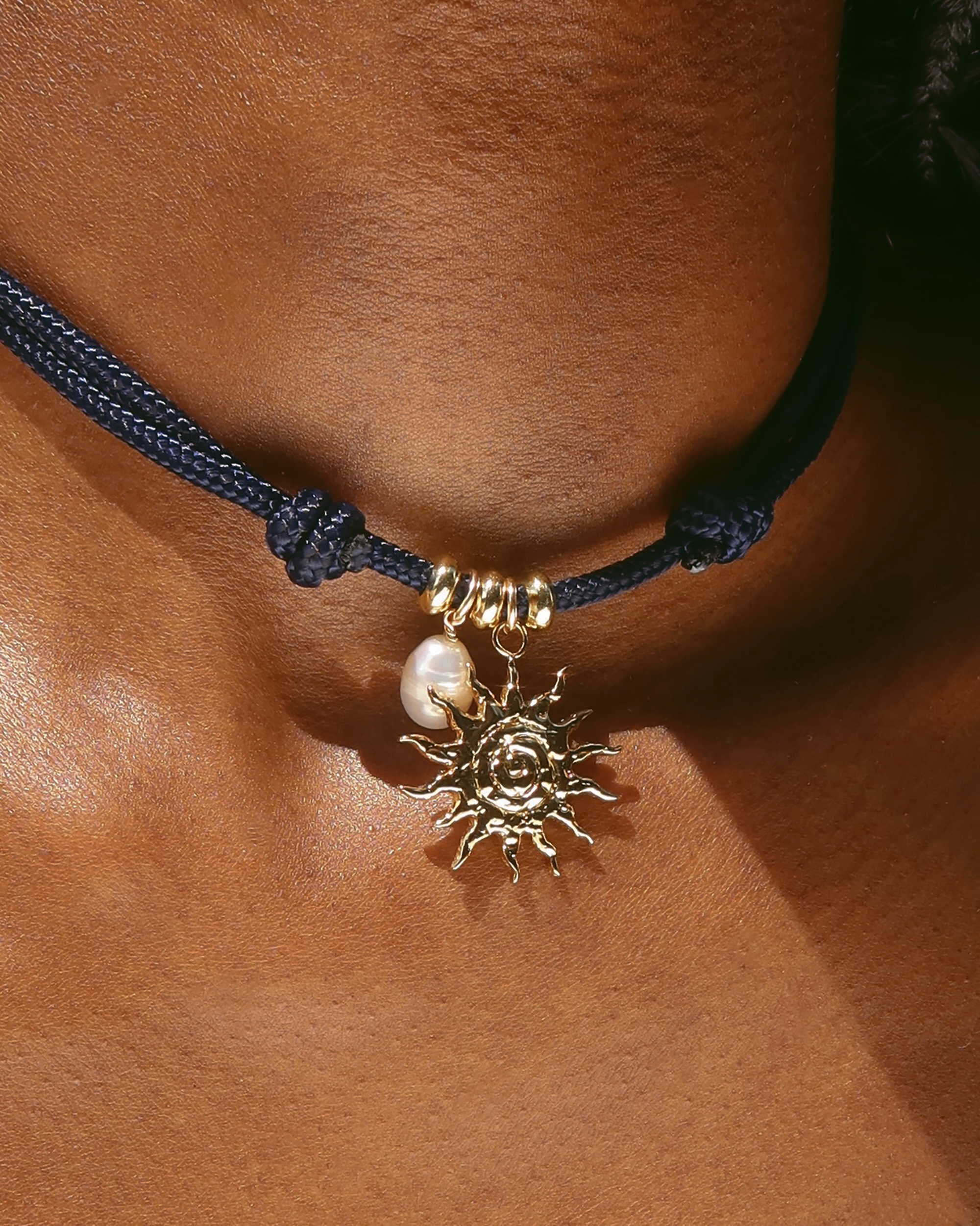 Bracelet with sun charm and pearl on skin