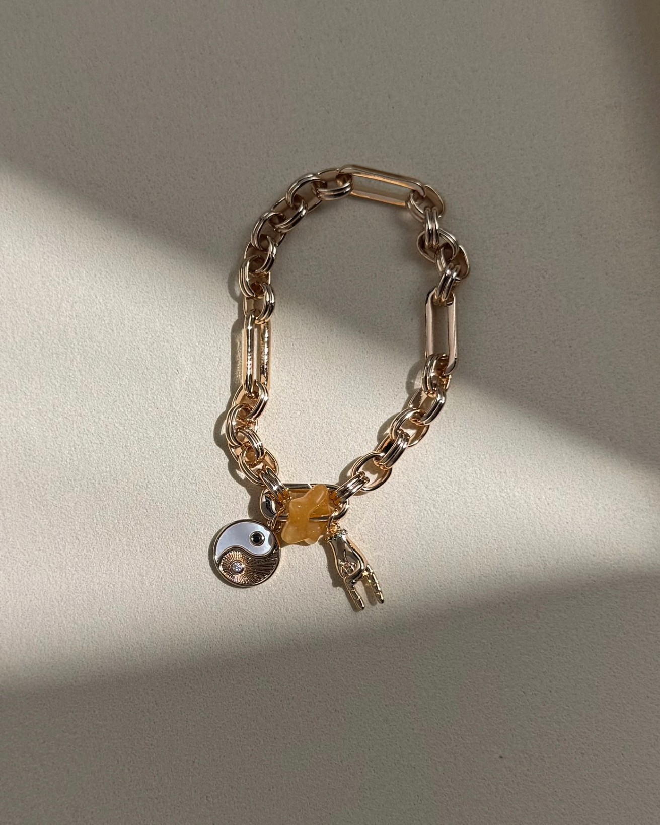 Chain bracelet with a lock and key charm on a light background