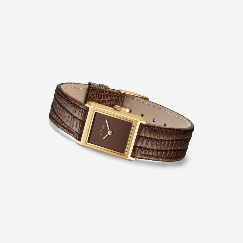 The Virgil Watch Small (Lizard Embossed) by Breda is a rectangular 18K gold-plated minimalist watch with a brown face and a brown textured leather band, shown on a plain light background.