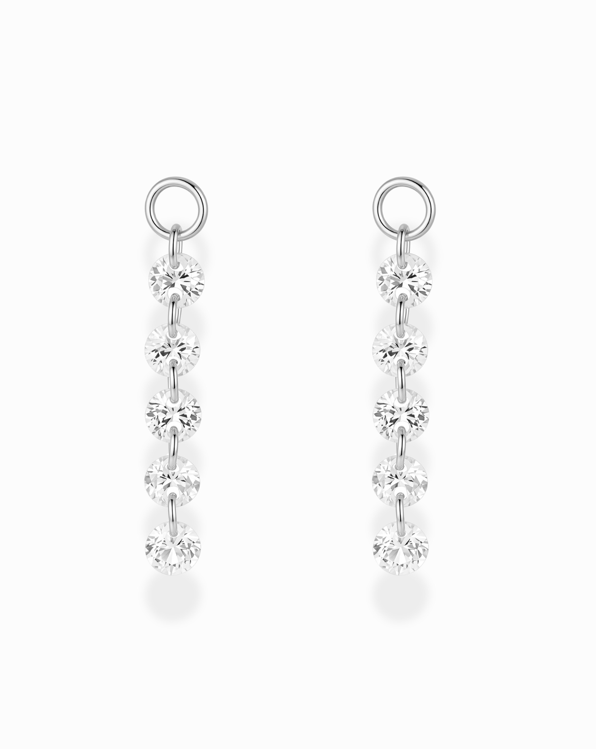 Mod + Jo Sade Sapphire Earring Charms: two silver-plated charms, each featuring a vertical row of five round, faceted lab-grown white sapphires hanging from a circular hoop.