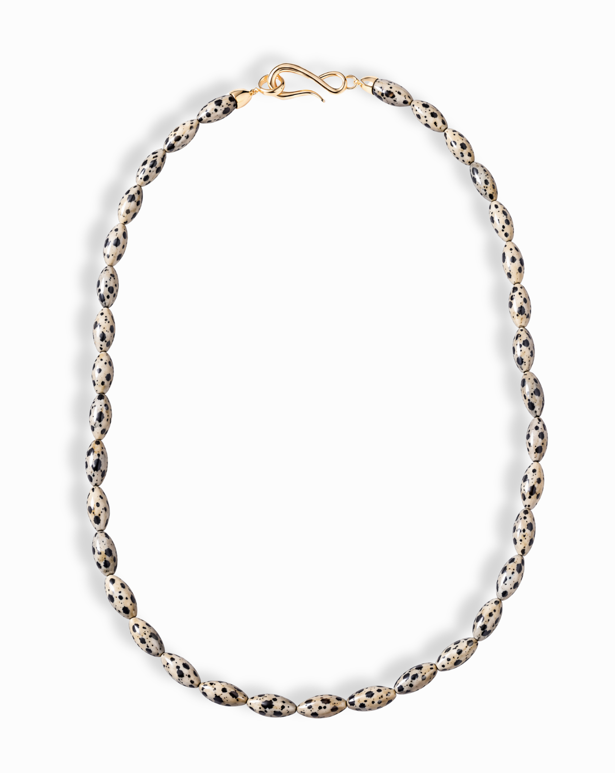 The Sutton Gemstone Necklace is an 18″ strand of rice-shaped Dalmatian jasper beads, finished with a gold S-hook clasp.