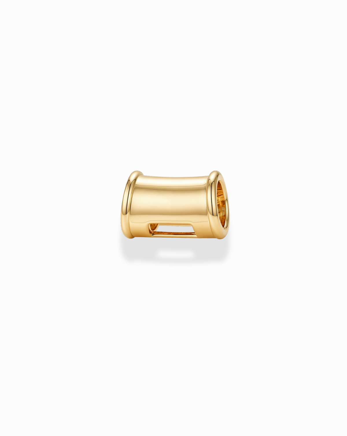 A polished gold, barrel-shaped Tash Charm Enhancer with a hollow center.