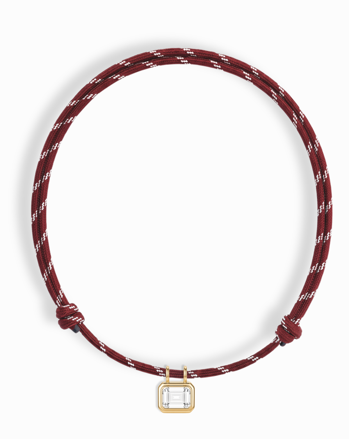 Introducing the Tommy Sapphire Pendant Necklace by Mod + Jo—a maroon rope necklace with white accents, showcasing a rectangular gold bezel-set, clear lab-grown white sapphire pendant at the center. This adjustable pendant necklace blends elegance and versatility, making it perfect for any occasion.